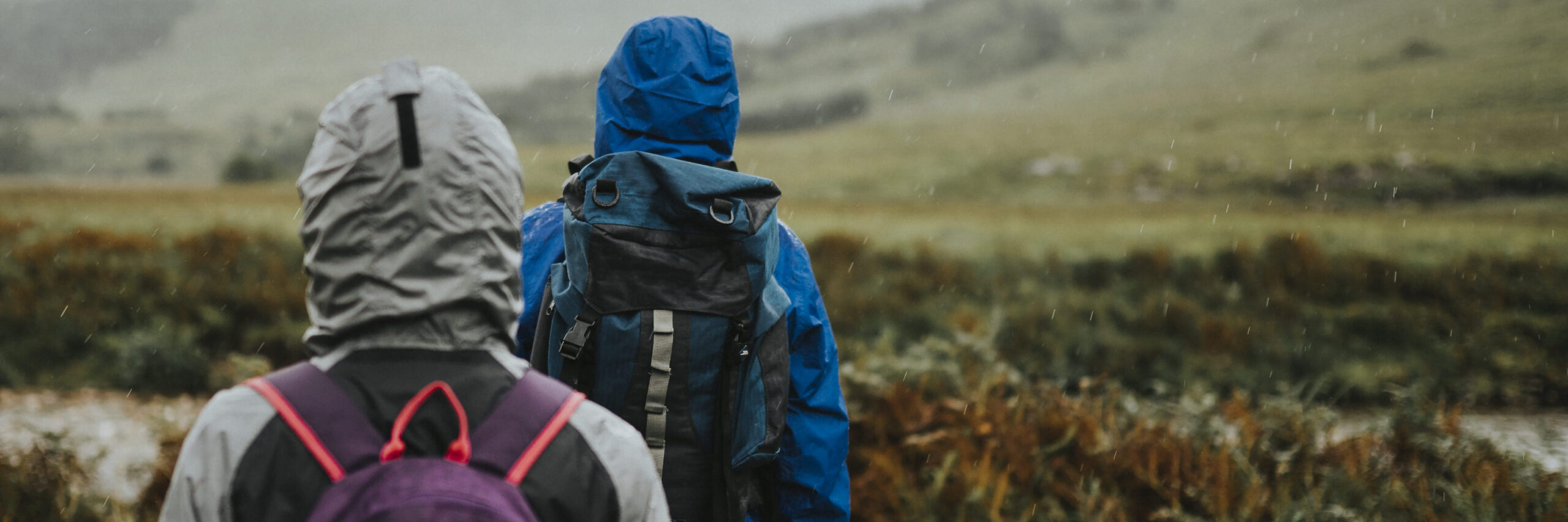 Couple trekking through the rain in the Highlands